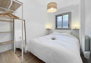 a white bedroom with a large bed and a window at L'escapade - Centre Ville - Parking - Balcon in Rennes