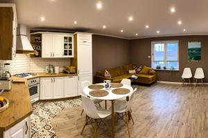 a kitchen and living room with a table and chairs at Domek z ogrzewaniem podłogowym in Wyszki