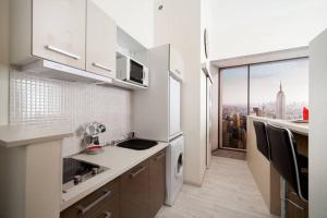 a white kitchen with a view of the city at Manhattan Studio in Budapest