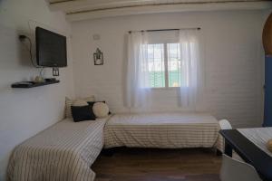 two beds in a room with a window at Complejo Willy Pampa in Barreal