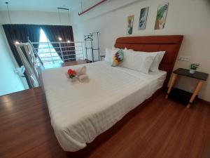 a bedroom with a large white bed with flowers on it at SY Staycation - Studio with Netflix in Bayan Lepas