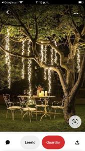 a table and chairs under a tree with lights at Aventurina in Jamundí