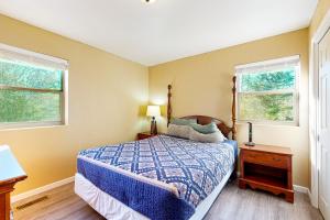 a bedroom with a bed and two windows at Logan's Hideaway in Eureka Springs