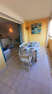 a room with a table and chairs in a room at SAVANNA BEACH I Joli T2 piscine vue mer Cap d'Agde in Cap d'Agde