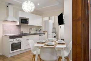 una cocina blanca con mesa y sillas. en Apartamento El Equilibrio, en Playa Honda