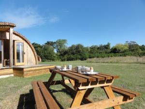 uma mesa de piquenique em frente a uma cabana em Cosy Cabins at Westfield Farm em Yarmouth