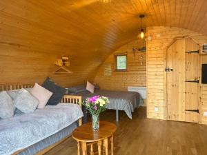 a living room with a couch and a bed and a table at Cosy Cabins at Westfield Farm in Yarmouth