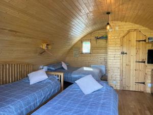um quarto com 3 camas num chalé de madeira em Cosy Cabins at Westfield Farm em Yarmouth