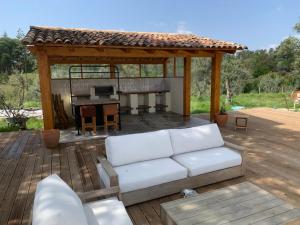 a white couch on a deck with a gazebo at Casinha Revira Volta in Nesperal