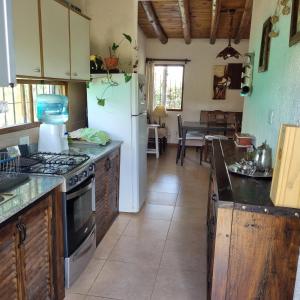 cocina con nevera blanca y mesa en El descanso, zona de bodegas en Luján de Cuyo