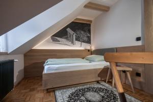 Habitación pequeña con cama y escritorio. en Guesthouse Pri Zalogarju, en Železniki