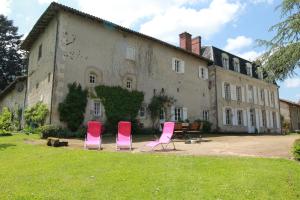 3 sedie rosa sedute di fronte a un edificio di Masbareau, Demeure de Charme, B&B a Royères-Saint-Léonard