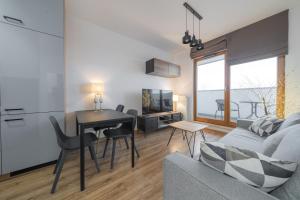 uma sala de estar com um sofá, uma mesa e uma cozinha em Apartament Kapitalny em Gdańsk
