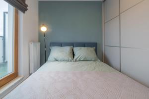a bed in a small room with a window at Apartament Kapitalny in Gdańsk