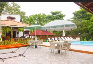 a patio with chairs and umbrellas next to a pool at Cabaña Villa Maria in San Antero