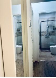 a bathroom with two sinks and a glass shower at Alkecè White in Udine