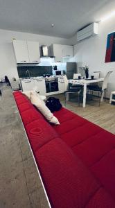 - un canapé rouge au milieu d'un salon dans l'établissement Alkecè White, à Udine
