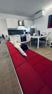 a red couch in the middle of a living room at Alkecè White in Udine