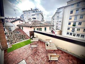 a view of a balcony with benches and buildings at Alkecè White in Udine