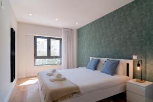 een slaapkamer met een groot bed met een groene accentmuur bij Modern 3 BDR Apartment by LovelyStay in Ramada