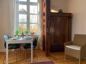 a dining room with a table and chairs and a window at Schloss Lelkendorf, Fewo Hoppenrade in Lelkendorf +17 photos