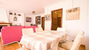 a dining room with a table and a pink couch at Vives Ref 9002 in Cala Bona +20 photos