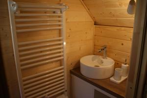 ein Badezimmer mit einem Waschbecken in einem Holzzimmer in der Unterkunft Les Cabanes du Grand Nord in Pradines