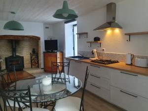 een keuken met een glazen tafel en een fornuis top oven bij La P'tite Maison in Carlux