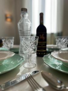 einen Tisch mit Tellern, eine Flasche Wein und ein Glas in der Unterkunft BRIC NEST il luogo ideale per la tua vacanza. in Florenz