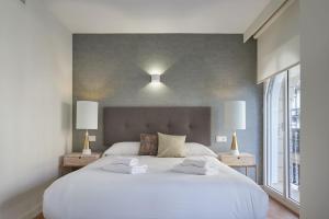 - une chambre avec un grand lit blanc et deux lampes dans l'établissement The Rentals Collection - Olabar II, à Saint-Sébastien