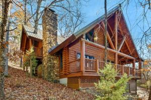 ein Blockhaus mit einer umlaufenden Terrasse in der Unterkunft Cinnamon Valley in Eureka Springs