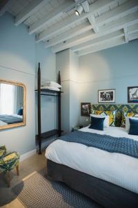 een slaapkamer met een groot bed en een spiegel bij Oever House in Antwerpen