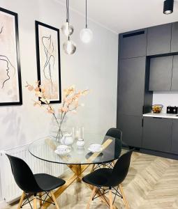 a dining room with a glass table and chairs at ApartCentrum-CHARLOTTE -PARKING-Air conditioning in Bolesławiec