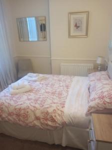 1 dormitorio con 1 cama con 2 toallas en Wedgwood Guest House, en Llandudno