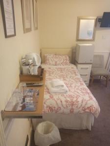 um pequeno quarto com uma cama e uma cómoda em Wedgwood Guest House em Llandudno