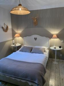 ブザンソンにあるChambre d'Hôtes La Villa Molinaのベッドルーム1室(白いベッド1台、テーブル2台、ランプ2つ付)