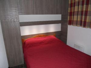 ヴァルフレジュスにあるAppartement Valfréjus, 4 pièces, 8 personnes - FR-1-265-172のベッドルーム1室(赤いベッド1台、木製ヘッドボード付)
