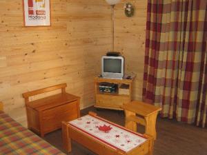 ヴァルフレジュスにあるAppartement Valfréjus, 3 pièces, 6 personnes - FR-1-265-181の木製の壁に小さなテレビが備わる客室です。