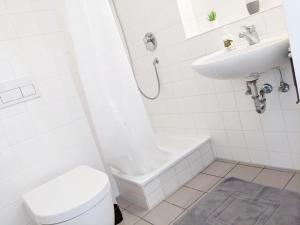 a white bathroom with a toilet and a sink at Tiny Apartment - Innenstadt l Smart TV l Küche in Kaiserslautern