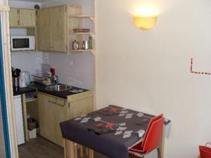 een kleine keuken met een tafel en een kleine keuken met een tafel en stoelen bij Studio Valfréjus, 1 pièce, 4 personnes - FR-1-265-234 in Valfréjus