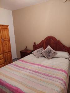 a bedroom with a bed with a striped blanket and a dresser at La Trinidad San Luis, La Punta in La Punta