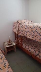 a bedroom with a bed and a nightstand with a bed sidx sidx at La Trinidad San Luis, La Punta in La Punta