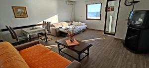 a living room with a couch and a tv at Apartments Abramovic 2 in Sutomore