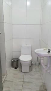 a white bathroom with a toilet and a sink at Terraço Ribeira Casa p Temporada in Salvador