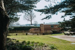 a wooden house in a yard with a fence at Luxury Twin Shepherds Hut - Cosy & Romantic in Llandudno