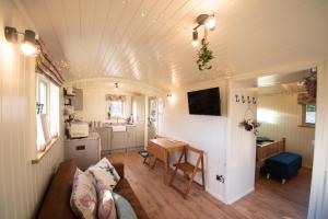 a living room with a couch and a table at Luxury Twin Shepherds Hut - Cosy & Romantic in Llandudno