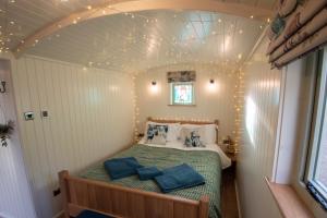 a bedroom with a bed in a small room at Luxury Twin Shepherds Hut - Cosy & Romantic in Llandudno