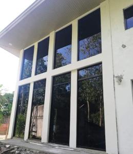 un edificio con ventanas grandes en un lateral en ES holiday home, en Zamboanga