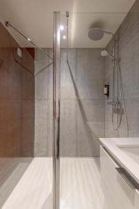 een douche met een glazen deur in de badkamer bij MiHotel Georges in Lyon