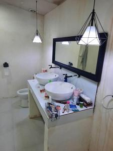 baño con 2 lavabos, espejo y aseo en ES holiday home, en Zamboanga